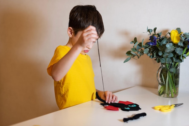 the boy is doing needlework Sewing a soft toy from felt hands closeup Pastime at home