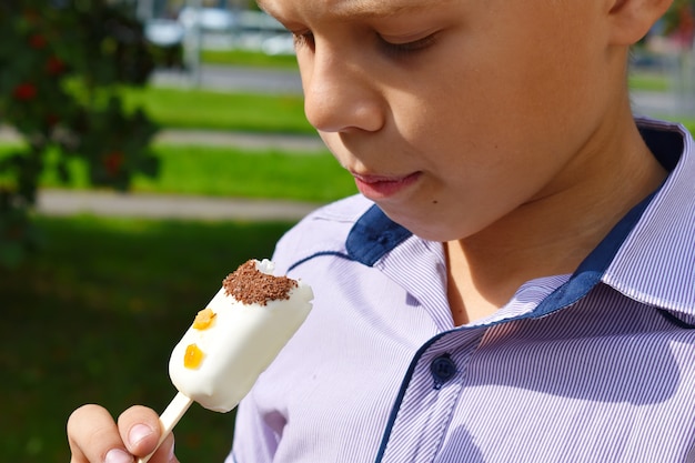 The boy is eating white ice cream