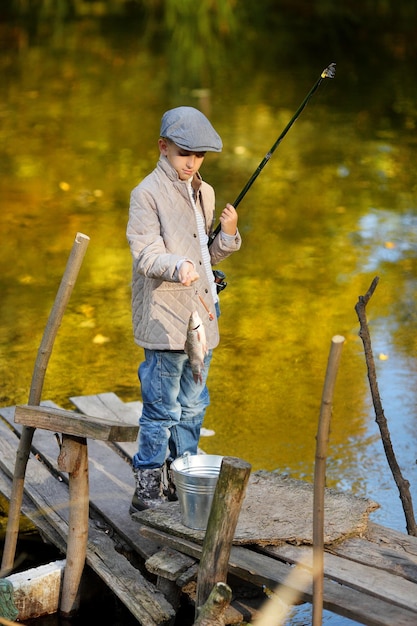 Boy is fishing at sunset on the lake