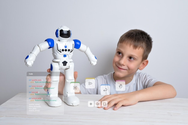 Фото Мальчик держит в руке робота с концептуальным кодом программирования робота