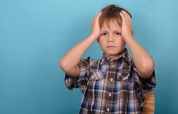 Photo boy is holding his head because of a headache