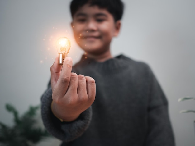 The boy is holding a light bulb It represents the concept of education learning innovation