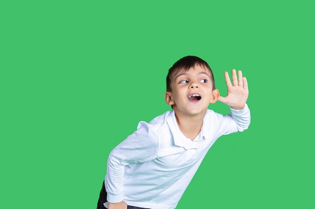 Un ragazzo sta ascoltando qualcosa con un orecchio sta prestando attenzione ascoltando ogni parola la camicia bianca indossa uno sfondo verde