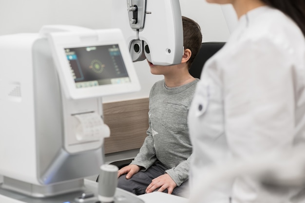 The boy is the patient on reception at doctor ophthalmologist Diagnostic ophthalmologic equipment