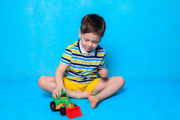 소년이 파란색 배경에서 타자기를 하고 있다 어린이 레저에 관한 기사 어린이 게임 어린이 자동차