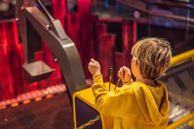 The boy is playing with a big toy excavator Construction concept Child development concept