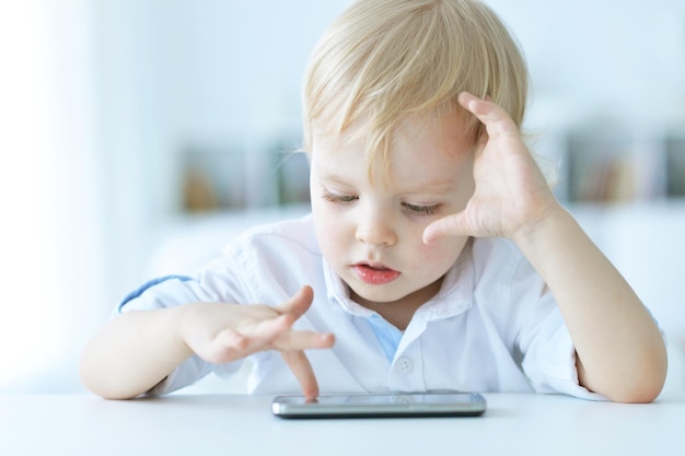 Boy is playing with a mobile phone