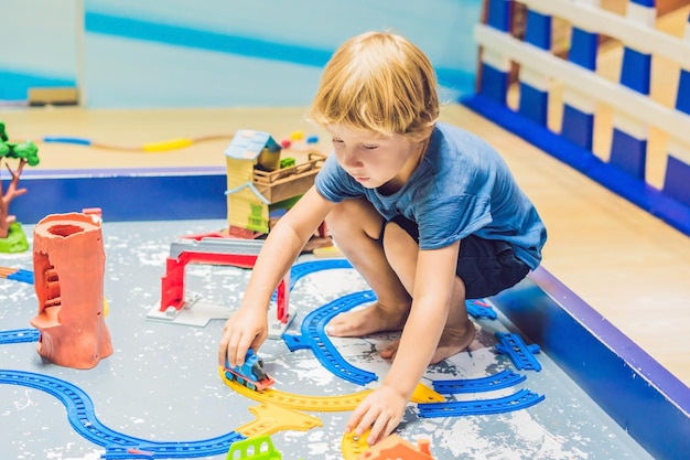 男の子がおもちゃの鉄道で遊んでいます。