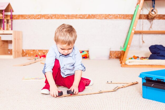 Boy is playing with wheels in the kindergarten