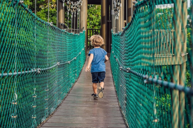 The boy is running on a suspension bridge in Kuala Lumpur, Malaysia