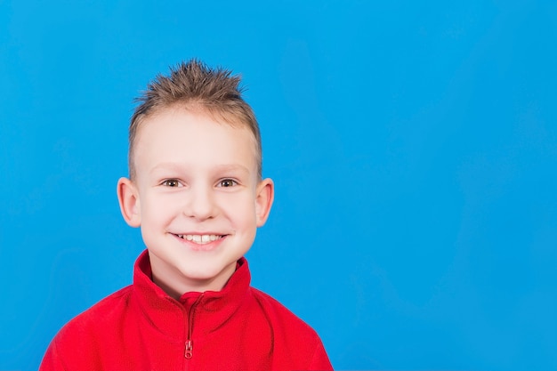 The boy is smiling on a blue surface