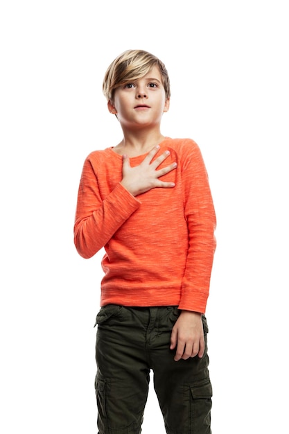 The boy is surprised and shocked. Emotional guy in an orange sweater. Isolated on white background. Vertical.