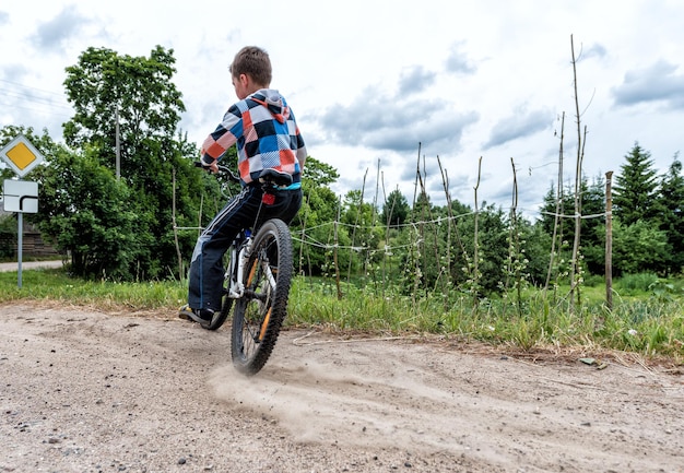 The boy is trying to drift on a bicycle