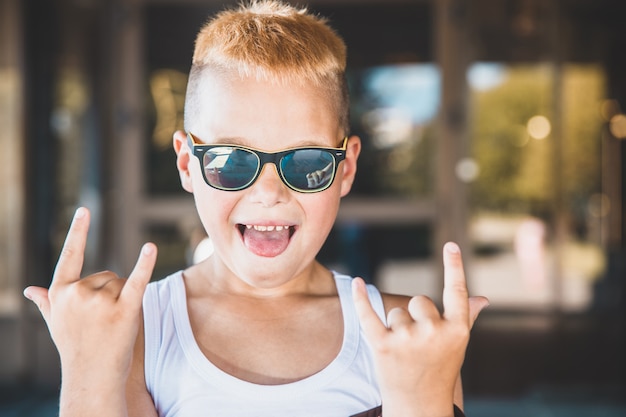 Boy in jeans and sunglasses in the city.