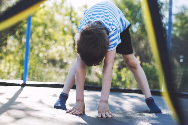 Boy jumping on trampoline the child plays on a trampoline outdoor