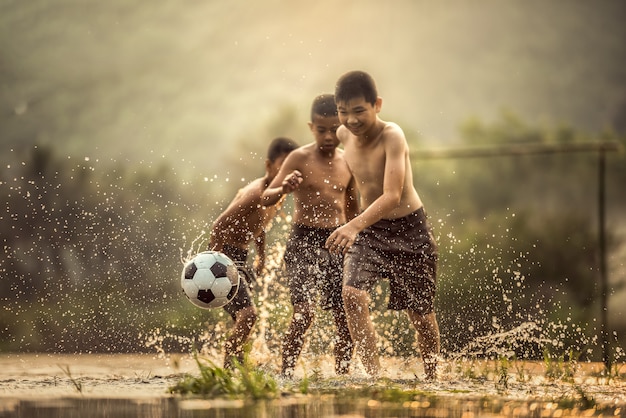 サッカーボールを蹴る少年（サッカーボールに焦点を当てる）