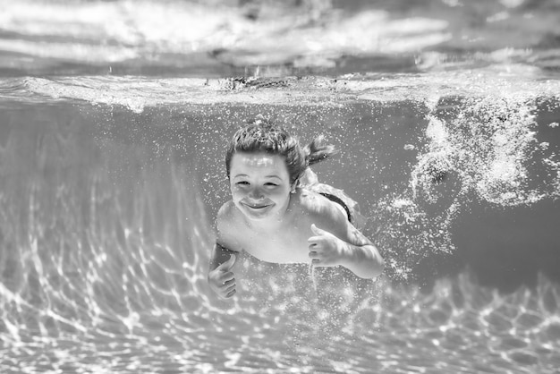 Boy kid swim and dive underwater Under water portrait in swim pool Child boy diving into a swimming