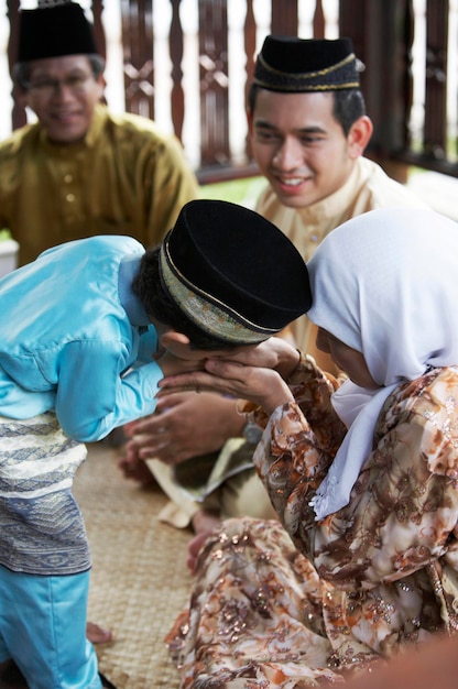 Photo boy kissing hands of grandmother while sitting in gazebo