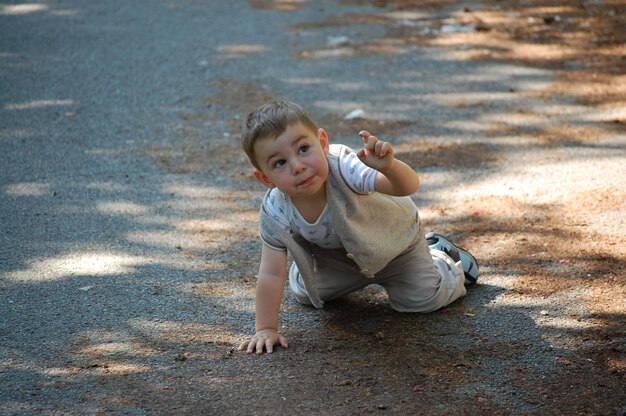 Photo boy kneeling on road