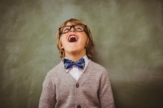 Boy laughing in front of blackboard