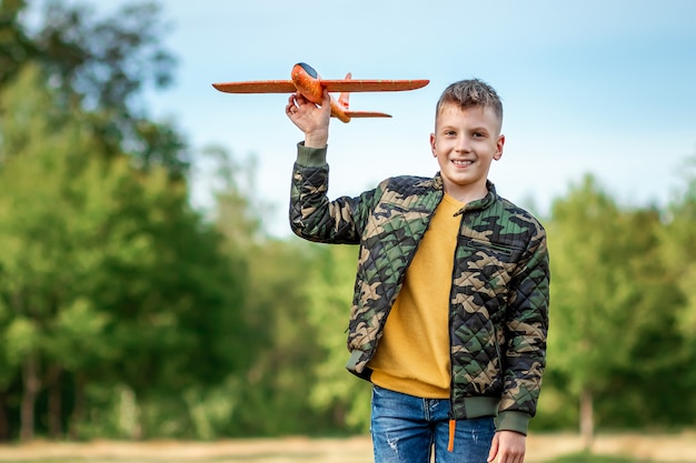 The boy launches a toy airplane.