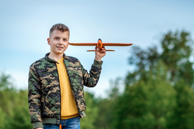 The boy launches a toy airplane.