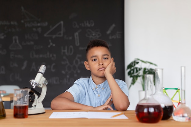 Foto ragazzo che impara di più sulla chimica in classe