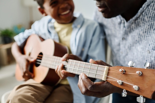 Boy learning to play guitar with teacher