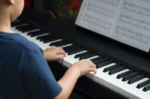 Foto il ragazzo impara a suonare il piano