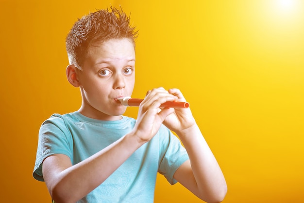 A boy in a light t-shirt playing on a pipe on a colored