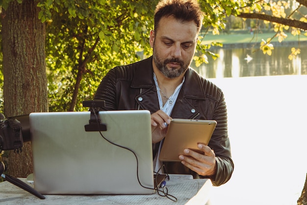 Ragazzo in live streaming che saluta i suoi follower in outdoor