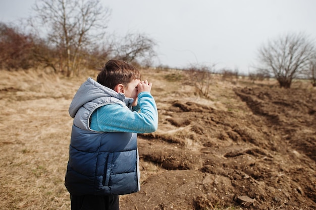 Boy look through hands binoculars