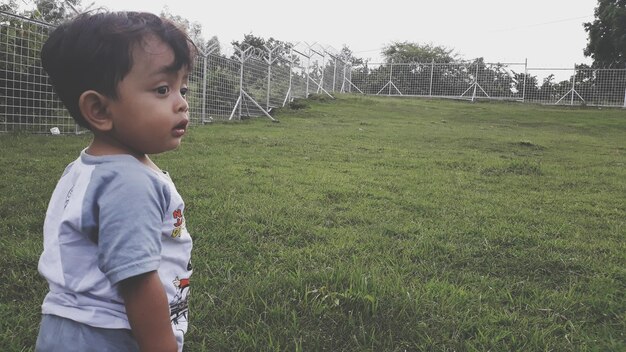 Foto ragazzo che guarda lontano sul campo