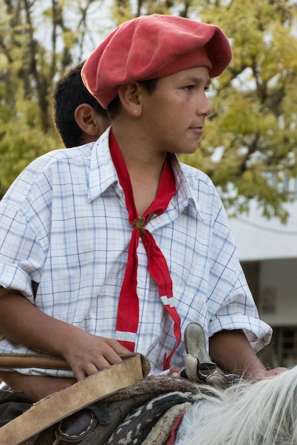 Foto ragazzo che guarda lontano mentre è seduto su un cavallo