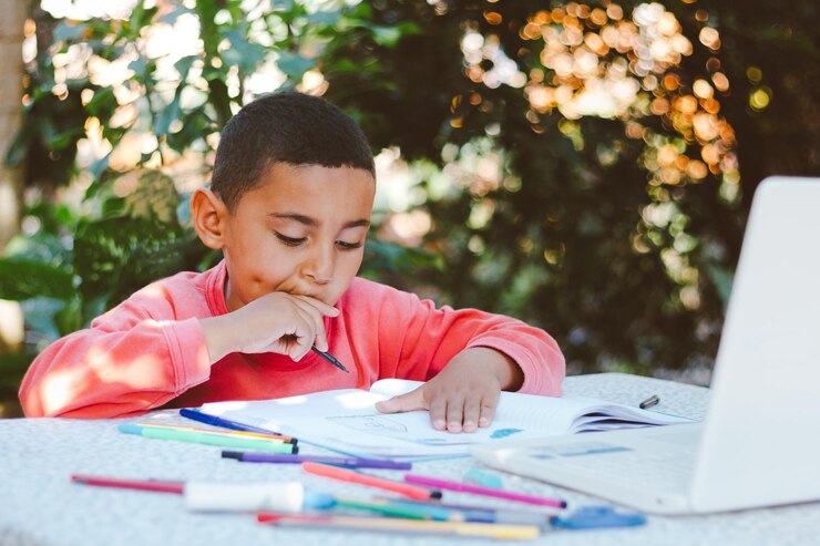 Photo boy looking away while sitting on table
