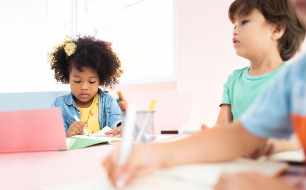 Photo boy looking away while sitting on table