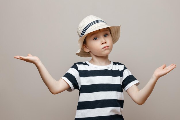 Boy looking away while standing against gray background