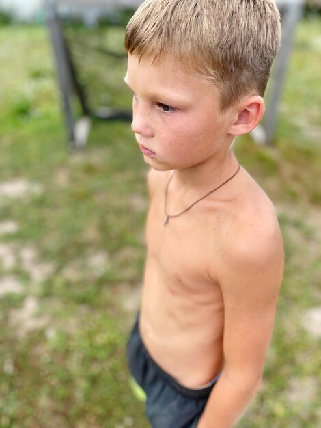 Photo boy looking away while standing outdoors