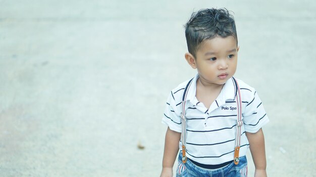Boy looking away while standing outdoors