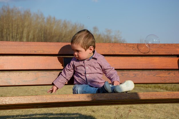 Boy looking away while standing on wood