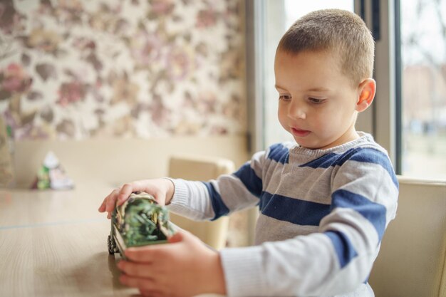 家でカメラを見ている少年