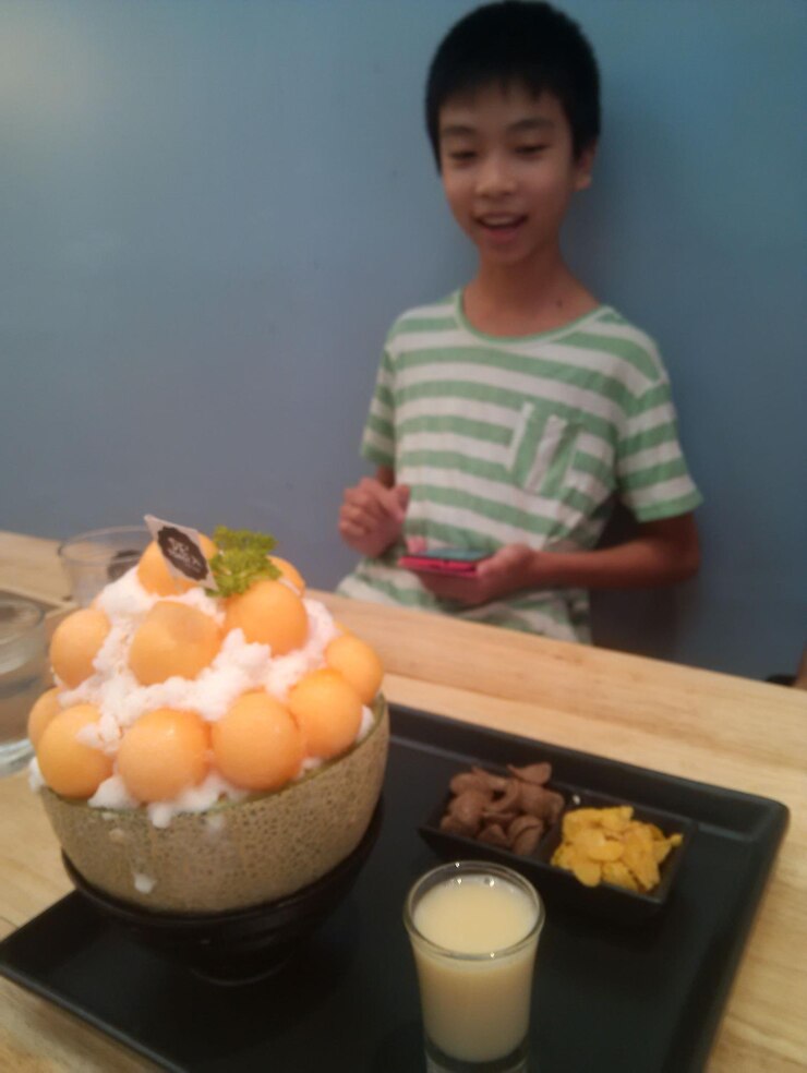 Photo boy looking at food while sitting in home