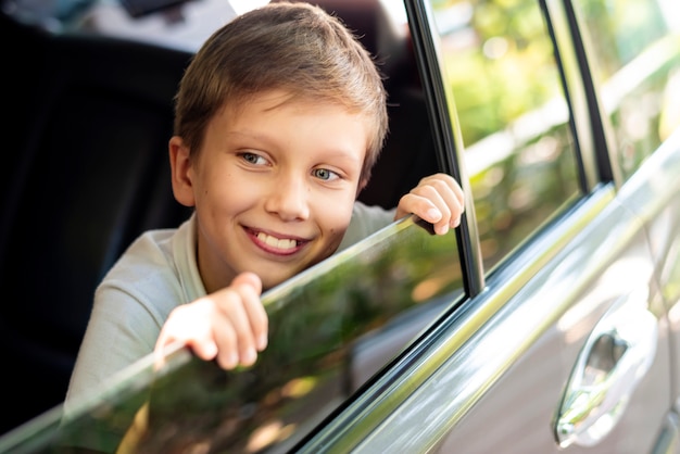 車の窓を見ている少年