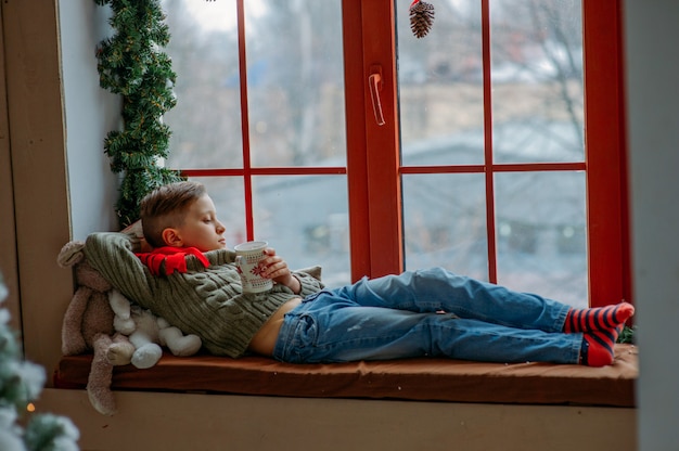 Boy looking out the window in Christmas season