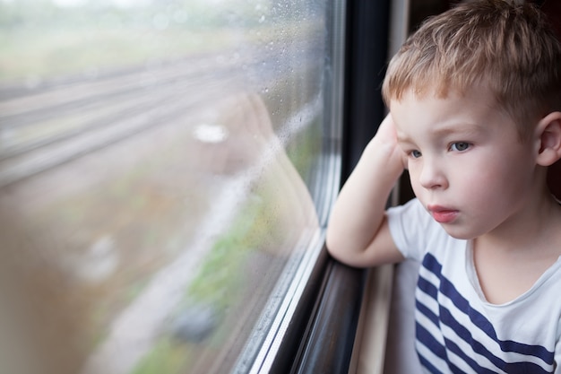 Boy looking out the window of train