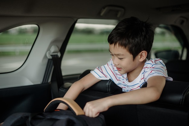 The boy looking at suitcase searching in car on motor way Summer car trip Happy family