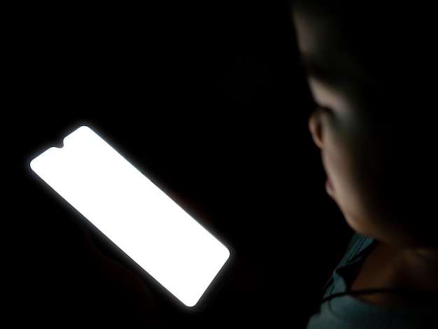 A boy looking at a white blank phone screen