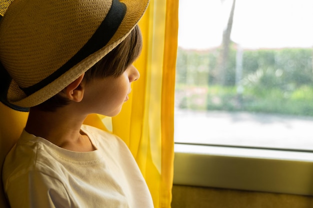 A boy looks out the window of a bus