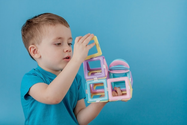 Boy looks through the shape in the color constructor with the connection of the magnets