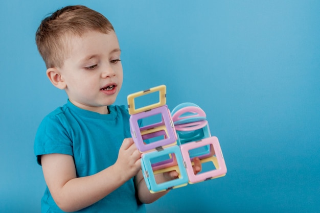 Boy looks through the shape in the color constructor with the connection of the magnets